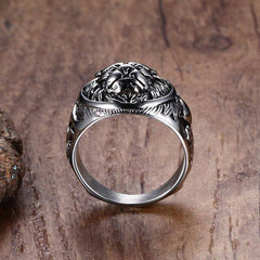Silver stainless steel lion head ring with detailed fierce lion design and rugged finish on wooden background