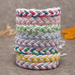 Stack of colorful handwoven cotton string bracelets with braided artistic patterns