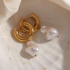 Chunky gold hoop Water Drop Earrings with removable baroque-style simulated pearl charms on marble background