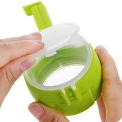 Green plastic food sealing clip with pour spout held in hand opening lid for kitchen use