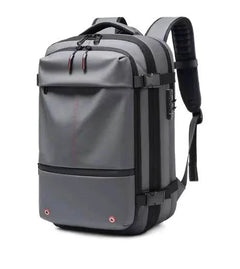 Gray vacuum compression backpack with multiple compartments, ergonomic padded straps, and USB charging port for travel.