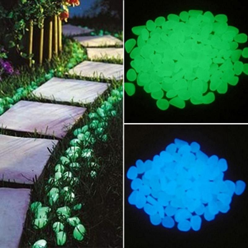 Glow in the Dark Garden Pebbles glowing green and blue along a garden pathway at night