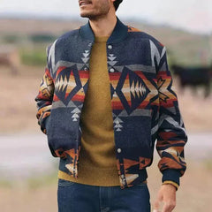 Man wearing a dark blue geometric pattern stand collar cardigan jacket over a brown sweater outdoors