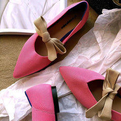 Pink flat casual boat shoes with pointed toes and beige bow detail, Mary Jane style flats.