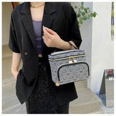 Woman holding gray Hello Kitty makeup bag with black accents and gold zipper details