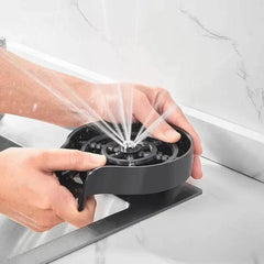Automatic glass cup washer with high-pressure water jets for efficient cleaning in bar or kitchen sinks.