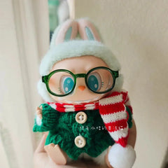 Labubu doll wearing green plastic round 【Labubu Glasses】 with winter hat and red striped scarf accessories.