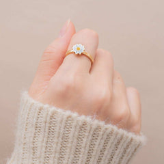 Close-up of a hand wearing a gold Fidget Spinner Rotatable Ring with a flower-shaped spinning centerpiece.