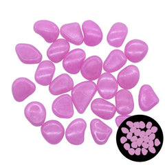 Pink glow in the dark garden pebbles glowing softly in the dark, decorative outdoor stones for pathways and aquariums