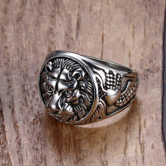 Electric silver stainless steel lion head ring with intricate detailing on wooden background