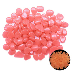 Pink glow in the dark garden pebbles made of durable resin, perfect for outdoor decoration and aquariums, glowing softly at night.