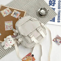 Compact Korean Nylon Oxford Fabric Versatile Literature Backpack in light grey with bear pendant and adjustable straps alongside decorative cards and a cup of tea