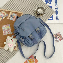 Blue Korean Nylon Oxford Fabric Versatile Literature Backpack with bear pendant and adjustable straps on checkered surface