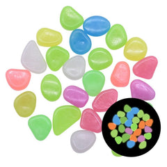 Colorful glow in the dark garden pebbles in various shapes, glowing brightly in green, blue, orange, and purple hues.